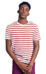 Young african american man wearing casual clothes relaxed with serious expression on face. simple and natural looking at the camera.