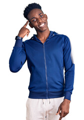 Young african american man wearing sportswear smiling pointing to head with one finger, great idea or thought, good memory