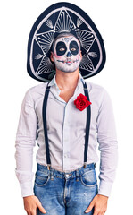 Man wearing day of the dead costume over background puffing cheeks with funny face. mouth inflated with air, crazy expression. - obrazy, fototapety, plakaty