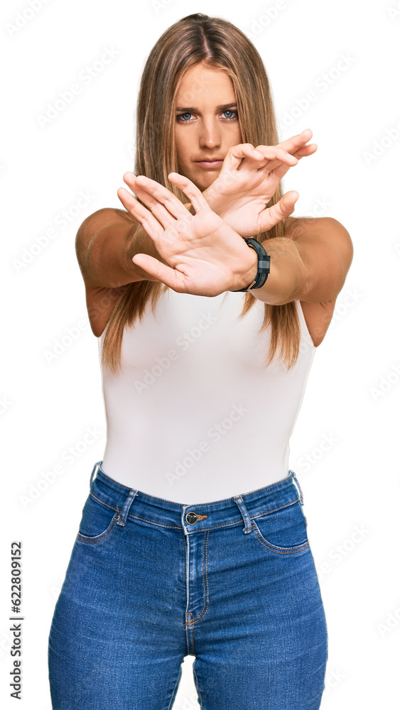 Wall mural young blonde woman wearing casual style with sleeveless shirt rejection expression crossing arms and - Wall murals