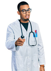 Young african american man wearing doctor uniform and stethoscope pointing displeased and frustrated to the camera, angry and furious with you