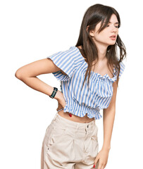 Young beautiful caucasian girl wearing casual clothes suffering of backache, touching back with hand, muscular pain