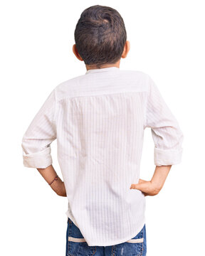 Cute blond kid wearing elegant shirt standing backwards looking away with arms on body