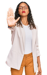 Young african american girl wearing business clothes doing stop sing with palm of the hand. warning...