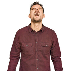 Young hispanic man wearing casual clothes angry and mad screaming frustrated and furious, shouting with anger. rage and aggressive concept.