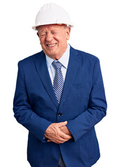 Senior handsome grey-haired man wearing suit and architect hardhat with hand on stomach because nausea, painful disease feeling unwell. ache concept.