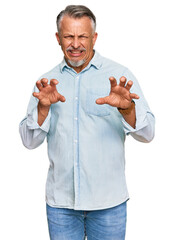 Middle age grey-haired man wearing casual clothes smiling funny doing claw gesture as cat,...