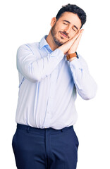 Young hispanic man wearing business clothes sleeping tired dreaming and posing with hands together while smiling with closed eyes.