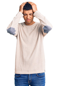 Young african amercian man wearing casual clothes suffering from headache desperate and stressed because pain and migraine. hands on head.