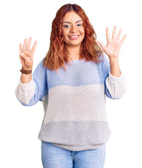 Young latin woman wearing casual clothes showing and pointing up with fingers number nine while...