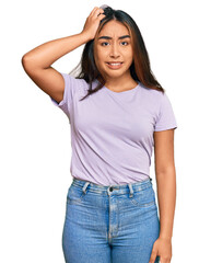 Obraz premium Young latin woman wearing casual clothes confuse and wonder about question. uncertain with doubt, thinking with hand on head. pensive concept.