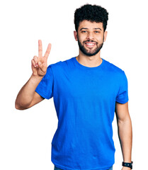 Young arab man with beard wearing casual blue t shirt smiling looking to the camera showing fingers doing victory sign. number two.