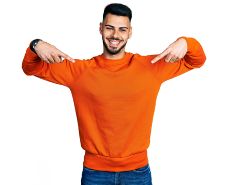 Young hispanic man with beard wearing casual orange sweater looking confident with smile on face, pointing oneself with fingers proud and happy.