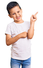 Little cute boy kid wearing casual white tshirt smiling happy pointing with hand and finger to the side