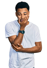 Young african american man wearing casual white t shirt thinking looking tired and bored with depression problems with crossed arms.