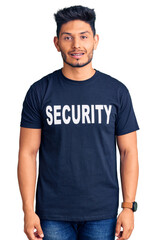 Handsome latin american young man wearing security t shirt with a happy and cool smile on face. lucky person.