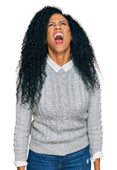 Middle age african american woman wearing casual clothes angry and mad screaming frustrated and furious, shouting with anger. rage and aggressive concept.