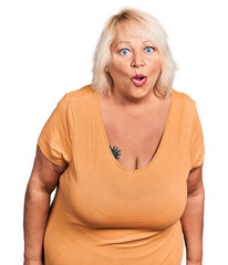 Middle age blonde woman wearing casual clothes scared and amazed with open mouth for surprise,...