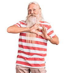 Old senior man with grey hair and long beard wearing striped tshirt smiling in love doing heart...