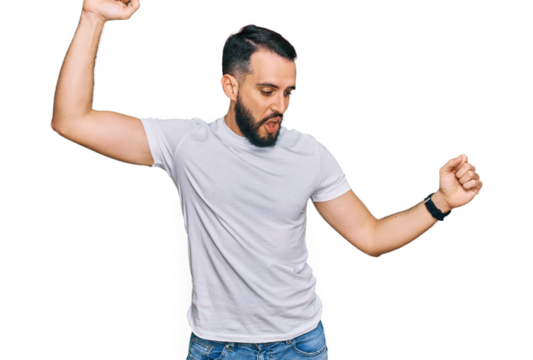 Young man with beard wearing casual white t shirt dancing happy and cheerful, smiling moving casual and confident listening to music
