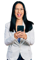 Beautiful hispanic woman with nose piercing using smartphone typing message winking looking at the...