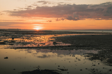 An amazing beach sunset glowing up an orange sky