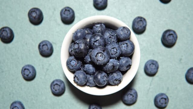 Fresh juicy blueberries on blue background, flat lay with copy space. Blueberries background. Concept of healthy nutrition, organic food. Vegan and vegetarian