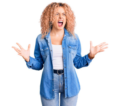 Young blonde woman with curly hair wearing casual denim jacket crazy and mad shouting and yelling with aggressive expression and arms raised. frustration concept.