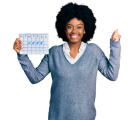 Young african american woman holding travel calendar screaming proud, celebrating victory and success very excited with raised arm