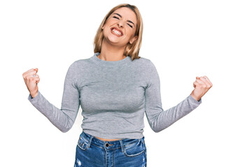 Obraz premium Young caucasian woman wearing casual clothes very happy and excited doing winner gesture with arms raised, smiling and screaming for success. celebration concept.