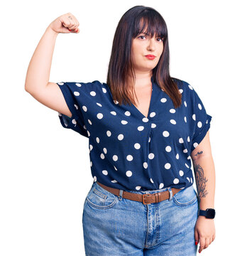 Young plus size woman wearing casual clothes strong person showing arm muscle, confident and proud of power