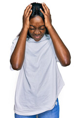 Naklejka premium Young african american woman wearing casual white t shirt suffering from headache desperate and stressed because pain and migraine. hands on head.