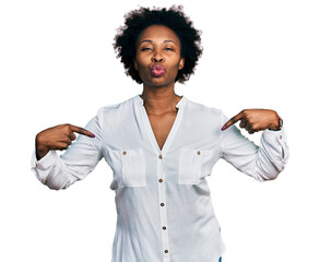 African american woman with afro hair pointing with fingers to herself looking at the camera...