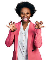 African american woman with afro hair wearing business jacket smiling funny doing claw gesture as...