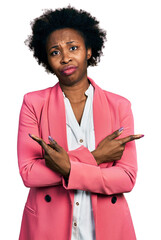 African american woman with afro hair wearing business jacket pointing to both sides with fingers,...