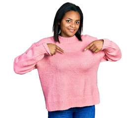 Beautiful hispanic woman wearing casual winter sweater looking confident with smile on face,...