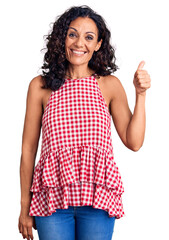 Middle age beautiful woman wearing casual sleeveless t shirt smiling happy and positive, thumb up...