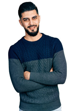 Young arab man with beard wearing casual sweater happy face smiling with crossed arms looking at the camera. positive person.