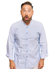 Handsome middle age man wearing business shirt afraid and shocked with surprise expression, fear and excited face.