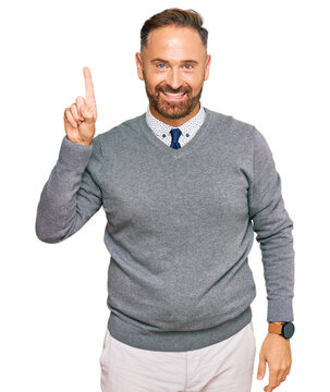 Handsome middle age man wearing business clothes pointing finger up with successful idea. exited and happy. number one.