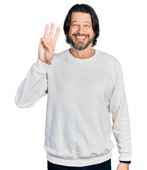 Middle age caucasian man wearing casual clothes showing and pointing up with fingers number three while smiling confident and happy.
