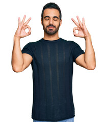 Young hispanic man wearing casual clothes relax and smiling with eyes closed doing meditation gesture with fingers. yoga concept.