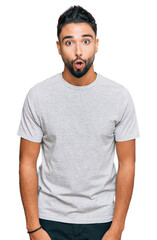 Young man with beard wearing casual grey tshirt afraid and shocked with surprise expression, fear and excited face.