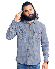 Young arab man wearing casual clothes shooting and killing oneself pointing hand and fingers to head like gun, suicide gesture.