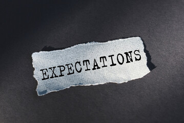 Expectations word written on torn paper. Close up