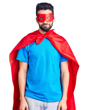 Young handsome man with beard wearing super hero costume smiling looking to the side and staring away thinking.