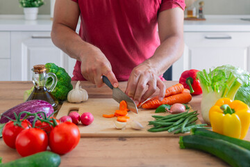 Obraz na płótnie Canvas Man hands cutting vegetables in the kitchen