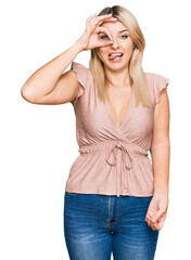 Young caucasian woman wearing casual clothes doing ok gesture like binoculars sticking tongue out, eyes looking through fingers. crazy expression.