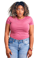 Young african american plus size woman wearing casual clothes in shock face, looking skeptical and sarcastic, surprised with open mouth