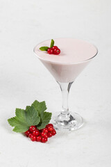 Red currant cream jelly, Panna Cotta, in a martini glass. White background. Close up